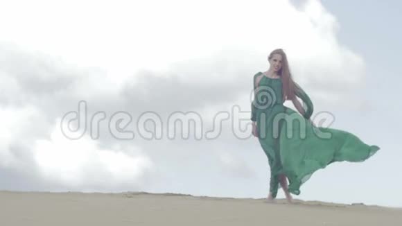 女孩站在沙丘上穿着绿色的衣服风视频的预览图