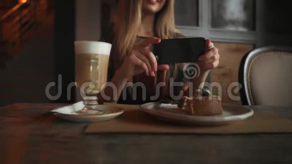 美丽的情感幸福的女孩正在咖啡馆里拍食物桌上拿铁甜点冰淇淋巧克力蛋糕视频的预览图