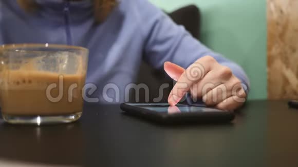 女人吃汉堡包喝咖啡浏览智能手机坐在快餐店生活方式视频的预览图