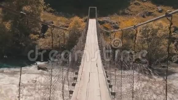 通过一座悬空的木桥向山河的另一边渡去悬桥山河漫步视频的预览图