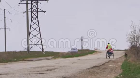 一个骑着反光背心的骑着三轮车在颠簸的道路上骑着电动尼龙的骑自行车的人视频的预览图