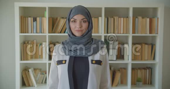 穆斯林年轻貌美的女医生戴着头巾在室内看着图书馆里的摄像机视频的预览图