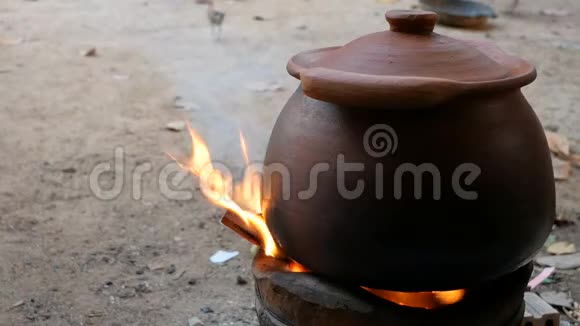 泥锅位于壁炉上有木柴和烟传统烹饪方法视频的预览图