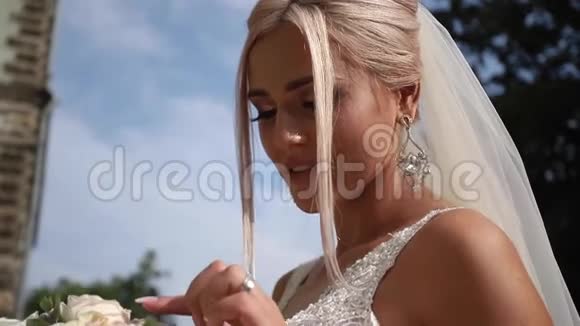 快乐的新娘带着婚礼花束漫步公园天气晴朗视频的预览图