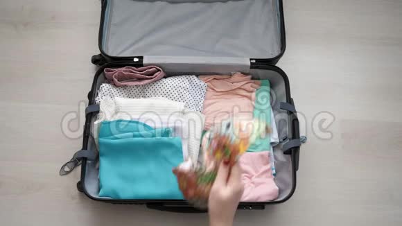 木制桌子上的旅行准备女人把衣服放在手提箱里视频的预览图