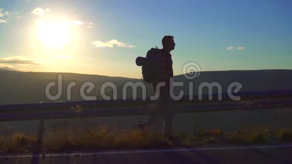 一个背着一个大背包手里拿着一个瓶子的旅行者正在路上视频的预览图