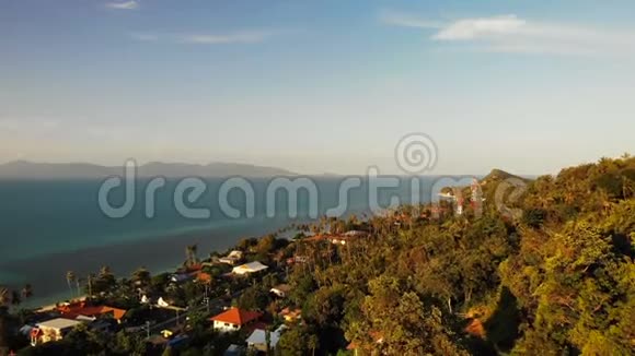 空中无人机视野丘陵海岸被碧海冲刷从上面看苏梅岛海滨有房屋公路和棕榈视频的预览图