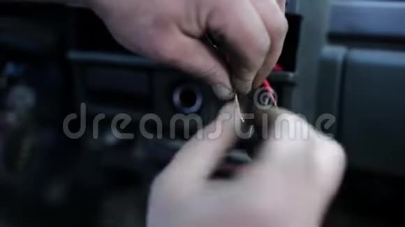 人的宏观视野他的手试图连接和绑两条裸露的红色电缆在汽车上视频的预览图