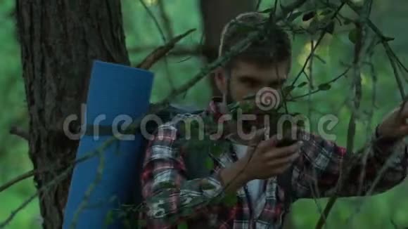 一个人在森林里散步试图打电话手机连接不好视频的预览图