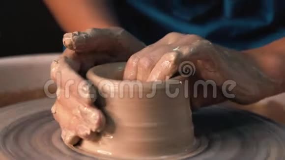 经验丰富的陶工用陶制工具塑造陶罐紧紧抓住在陶工车轮上工作的男性双手视频的预览图