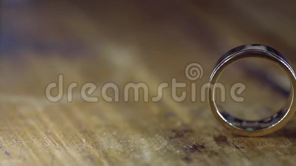 木质地板上的金色结婚戒指背光的宏观特写镜头耀斑钻石首饰视频的预览图