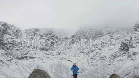 一个背着背包的人走在大山的背景上视频的预览图