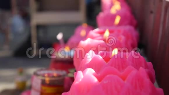 在庆祝中国新年的时候在道观点燃粉红蜡烛的火焰4k视频的预览图