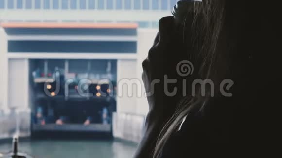 在一个寒冷的雾蒙蒙的早晨一位年轻快乐的女游客在渡船上喝咖啡特写剪影视频的预览图