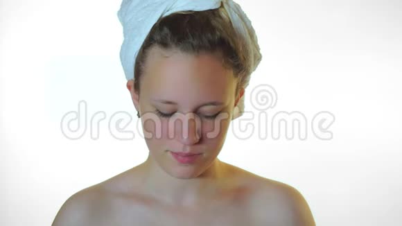 少女在脸上涂润肤霜白色背景视频的预览图