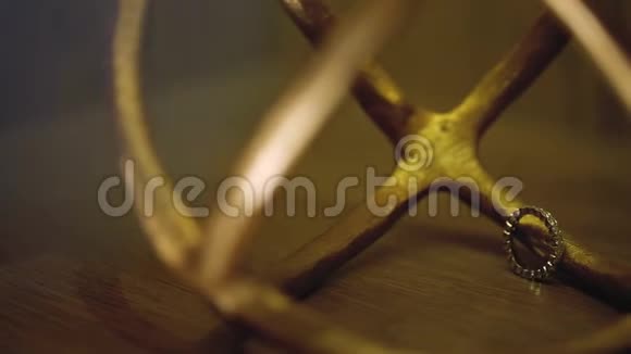 木质地板上的金色结婚戒指背光的宏观特写镜头耀斑钻石首饰视频的预览图