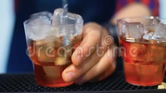 酒吧的酒吧服务员准备鸡尾酒加冰搅拌酒精饮料视频的预览图