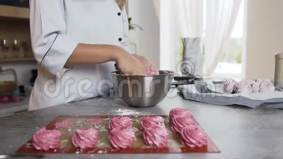 女厨师在时尚的厨房里用糖粉装饰棉花糖视频的预览图