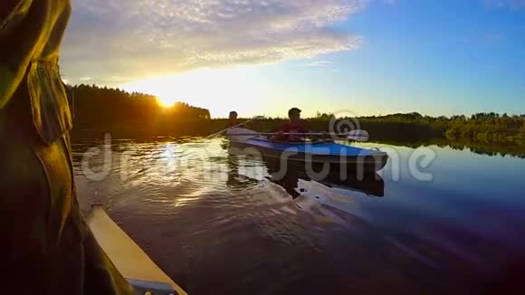 日落时两只雄性皮划艇的剪影活动休息慢动作视频的预览图