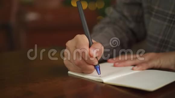 4K视频女人手写在白色笔记本上计划在桌子上的工作在咖啡馆里的bokeh灯视频的预览图