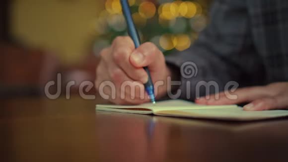 4K视频女人手写在白色笔记本上计划在桌子上的工作在咖啡馆里的bokeh灯视频的预览图