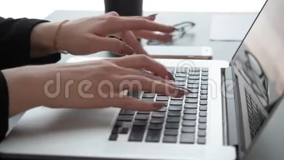 女性手在桌上的笔记本电脑键盘上打字视频的预览图