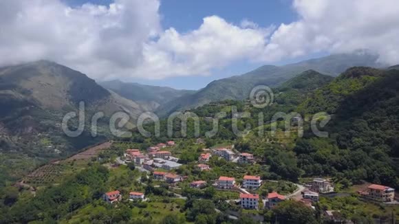 山顶上的村庄鸟瞰青山峡谷在红瓦屋顶的建筑物上飞行视频的预览图