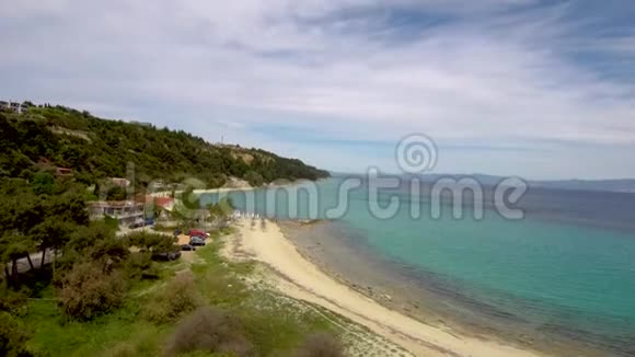 鸟瞰绿松石令人叹为观止的海滩下的一个旅游村阿西托斯Halkidiki希腊向上移动无人机视频的预览图