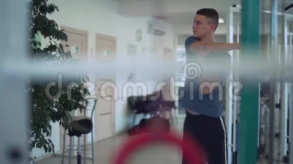 年轻人在健身房训练前揉捏他的手年轻人的健康生活方式视频的预览图