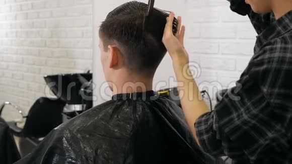 理发店女手理发师带电动剃须刀的刮胡子男子视频的预览图