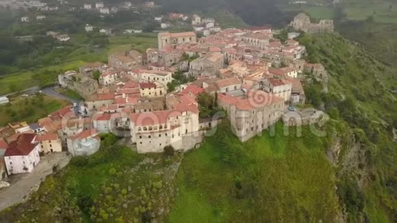 鸟瞰无人机飞越中世纪的村庄在山上俯瞰一个山峡意大利卡拉布里亚的阴天视频的预览图