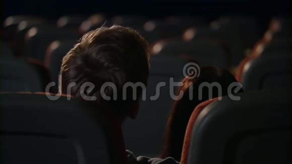 年轻人在空荡荡的电影院大厅里热情地接吻情侣接吻视频的预览图