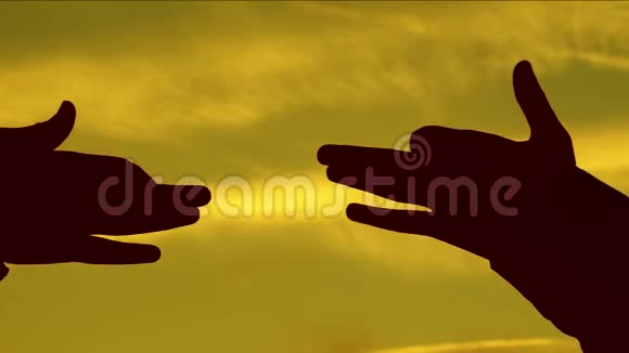孩子们在日落时用手做狗的形状女孩用手指握住一个狗符号的手势用手指抵住视频的预览图