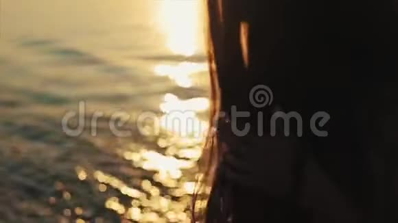 女孩们棕色的长发和夕阳在水中的倒影视频的预览图
