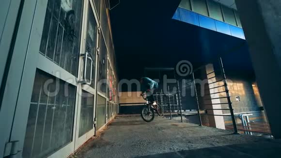 男青少年正在一座空房子里骑自行车特技表演视频的预览图