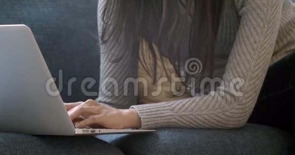 在沙发上用笔记本电脑打字的远程女工视频的预览图
