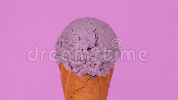 华夫饼锥中的薰衣草冰淇淋在粉红色背景上旋转液体巧克力酱倒在上面美味可口视频的预览图