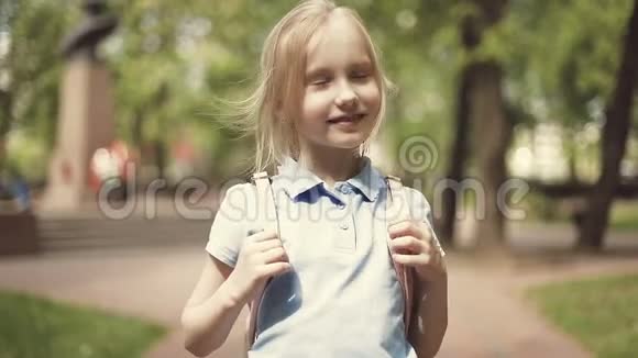 一个穿短裤的开朗金发女孩在夏天的公园里散步视频的预览图