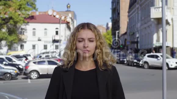在城市的街道上尖叫的金发女人闭着眼睛捂住耳朵视频的预览图