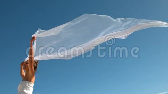 无忧无虑的金发女郎挽着围巾在风中飘扬视频的预览图