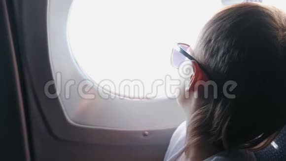 面目全非的男孩戴着太阳镜望着窗外的飞机视频的预览图