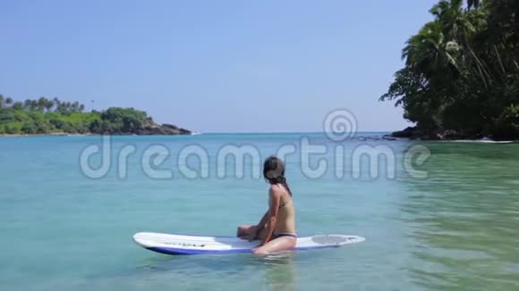 女孩漂浮在冲浪板上视频的预览图
