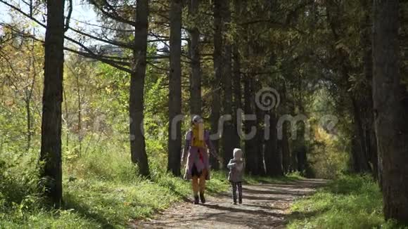 女人和小女孩走在秋天的小巷里视频的预览图