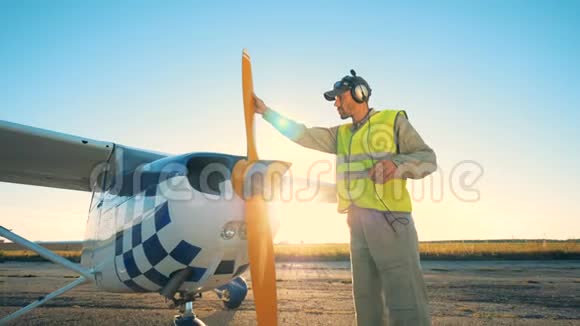一名飞行员站在跑道上的一个庄稼人旁边在开阔的田野里视频的预览图