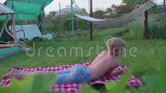 那个家伙在炎热的夏天躺在草坪上4这个孩子玩得很开心而且很活跃视频的预览图