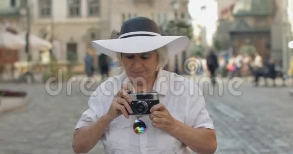 高级女游客探索小镇用复古相机拍照视频的预览图