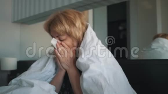 一个感冒的女人感觉不好吹进鼻子里裹着一条白色的毯子医生医疗帮助视频的预览图