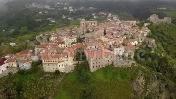 鸟瞰无人机飞越中世纪的村庄在山上俯瞰一个山峡意大利卡拉布里亚的阴天视频的预览图
