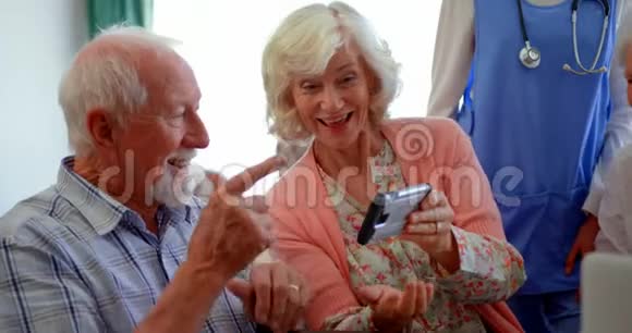 活跃的高加索族老年人在养老院用手机看照片4k视频的预览图