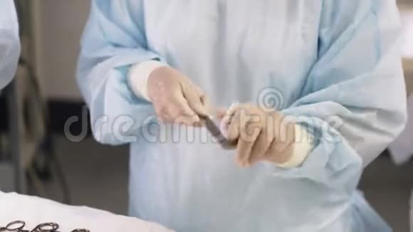 在手术过程中用手套将护士的手闭上消毒擦拭医疗器械的血液视频的预览图